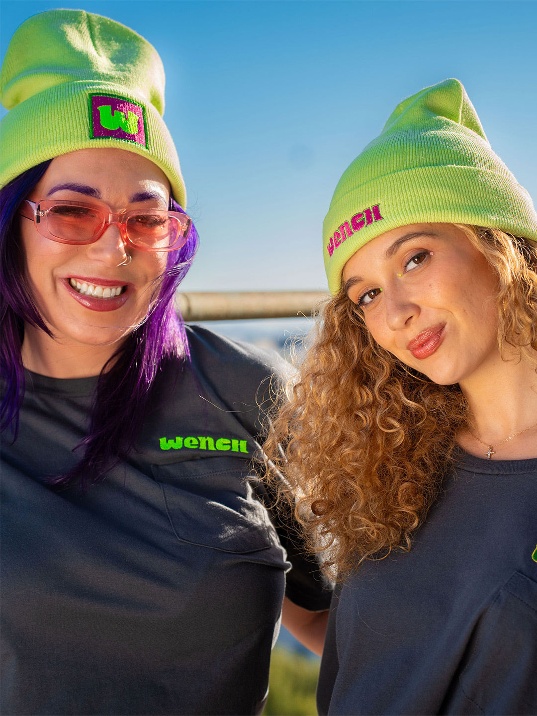 Wenches 2024 Unisex Pocket Tee Green Yellow and Lime Green Logos worn with W and Wenches Grass is Greener Beanies