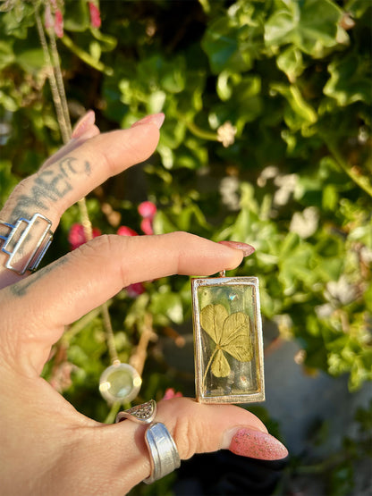 Rectangular clover resin earring single shown in the sun