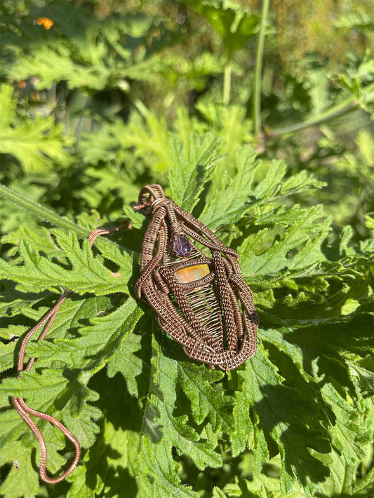 ammolite and amethyst pendant close up shot on leaf